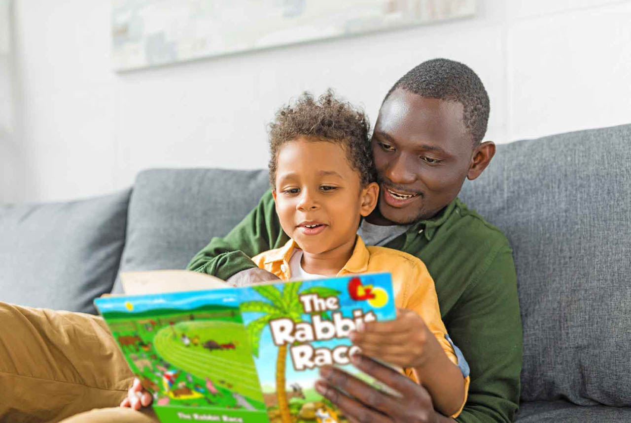 Dad reading The rabbit race Book with son.